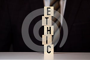 Wooden blocks with the word Ethic. Defending, systematizing and recommending concepts of right and wrong conduct.