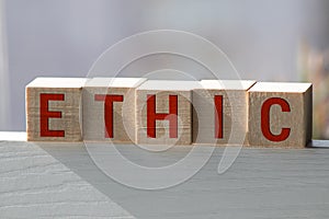 Wooden blocks with the word Ethic. Defending, systematizing and recommending concepts of right and wrong conduct. Moral philosophy