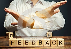Wooden blocks with the word Feedback and critic. The concept of the bad rating of hotels and restaurants. The evaluation of photo