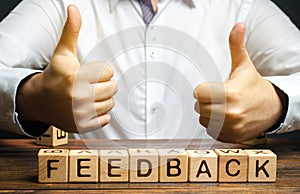 Wooden blocks with the word Feedback and hand up. The concept of the rating of hotels and restaurants. The evaluation of visitors