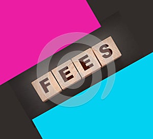 Wooden blocks with the word Fees . Taxes and fees business concept