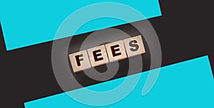 Wooden blocks with the word Fees . Taxes and fees business concept