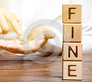 Wooden blocks with the word Fine and a man who calculates the size of the fine. Monetary penalty imposed in the form of punishment