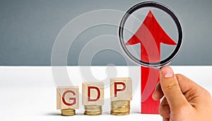 Wooden blocks with the word GDP and up arrow. Technological progress, increasing the level of workers, improving the allocation of photo