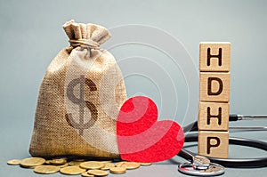 Wooden blocks with the word HDHP and money bag with dollar sign. High-deductible health plan concept. Health insurance plan with