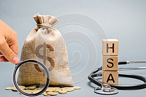Wooden blocks with the word HSA and money bag with stethoscope. Health savings account. Health care. Health insurance. Investments photo