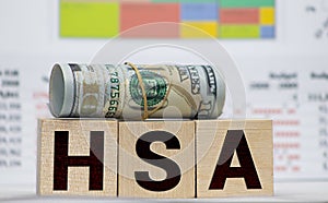 Wooden blocks with the word HSA and money bag with stethoscope. Health savings account. Health care. Health insurance. Investments