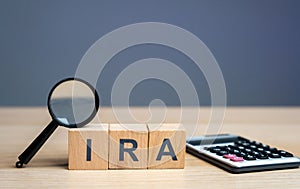 Wooden blocks with the word IRA - individual retirement account. Tax-advantaged account that individuals use to save and invest