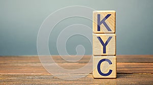 Wooden blocks with the word KYC - Know Your Customer / Client. Verify the identity, suitability and risks involved with