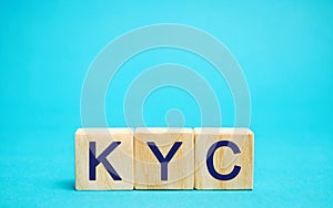 Wooden blocks with the word KYC - Know Your Customer / Client. Verify the identity, suitability and risks involved with photo