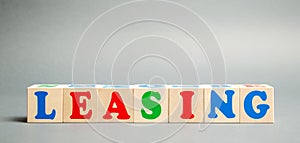 Wooden blocks with the word Leasing. Rental with repurchase rights. Acquisition of expensive goods - transport, real estate.