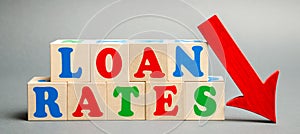 Wooden blocks with the word Loan rates and arrow down. The concept of low mortgage rates. Real estate market. Housing. Credit.