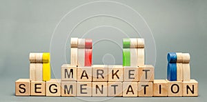 Wooden blocks with the word Market Segmentation and multicolored groups of people. Target audience, customer care. Market group of