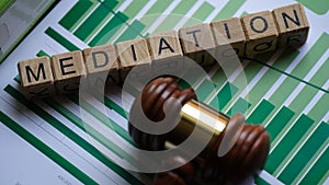 Wooden blocks with word mediation and judge gavel on stats documents