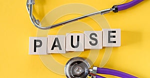 Wooden blocks with the word Pause. Break time concept in medicine. Stop the
