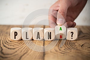 Wooden blocks with word PLAN and decision between plan A and plan B