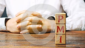 Wooden blocks with the word PMI - Purchasing ManagersÃ¢â¬â¢ Index. Economic indicators derived from monthly surveys of private photo