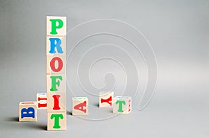 Wooden blocks with the word Profit and randomly scattered cubes. The financial result of the company for a certain period of time