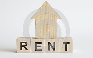 Wooden blocks with the word RENT , house. The concept of rent for an apartment or home. Interest rates are rising