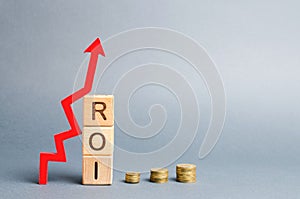 Wooden blocks with the word ROI and arrow up. High level of business profitability. Return on investment, invested capital, rate.