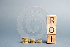 Wooden blocks with the word ROI and coins. High level of business profitability. Return on investment, invested capital, rate.