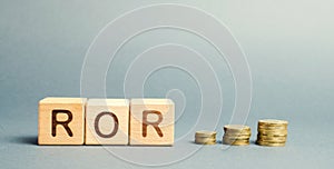 Wooden blocks with the word ROR. Rate of return. The level of profitability or loss of business. Financial ratio. Return on