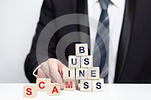 Wooden blocks with word scam, business fraud, scam and crime concept