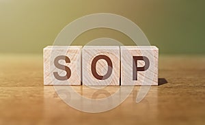 Wooden blocks with the word SOP - Standard operating procedure. Instructions to assist employees in complex routine operations.