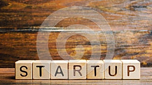 Wooden blocks with the word Startup. Temporary structure designed to find and implement a scalable business model. The concept of