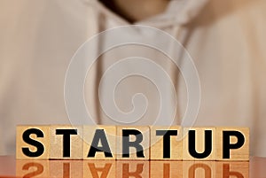 Wooden blocks with the word Startup. Temporary structure designed to find and implement a scalable business model. The concept of