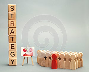 Wooden blocks with the word Strategy, business schedule and team of employees. Business strategy is an integrated model of actions