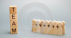 Wooden blocks with the word Team and a crowd of workers. The concept of a strong reliable business team. Teamwork. Team management