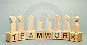 Wooden blocks with the word Teamwork and business team of employees. The concept of cooperation. Constructive feedback. Joint