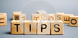 Wooden blocks with the word Tips and randomly scattered cubes. Award for good service in the cafe restaurant. A gratuity is a sum photo