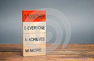 Wooden blocks with the word Together, Everyone, Achieves, More. Teamwork and team concept. Community, support, partnership.