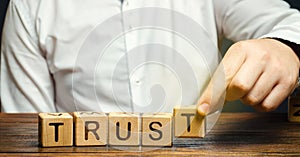 Wooden blocks with the word Trust. Trust relationships between business partners, friends, relatives. Respect and authority.