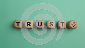 Wooden blocks with the word Trust. Trust relationships between business partners, friends, and relatives. Respect and authority.