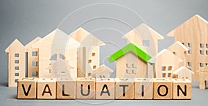 Wooden blocks with the word Valuation and many houses. Resale residential property condition. The study of the state of the house