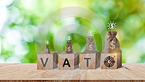 Wooden blocks with the words VAT target icon and money bag and coins, Taxes payment concept, Tax evasion, Taxation, Business and