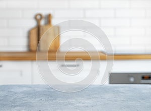 Wooden blue countertop with free space for mounting a product or layout against the background of a blurred white kitchen with