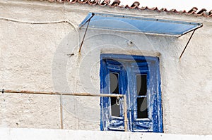 Wooden blue front door and windows on a dilapidated house