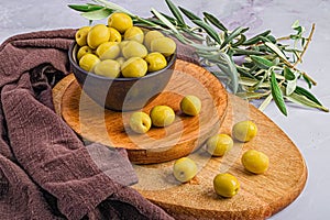 Wooden board with an array of ripe green Manzanilla Olives and other decorations photo