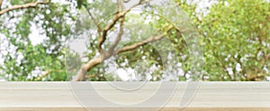 Wooden board empty table blurred background. Perspective brown wood table over blur trees forest background.