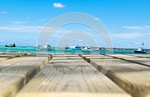 Wooden board empty table in front of blue sea, yachts