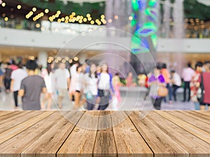 Wooden board empty table in front of blurred background. Perspective brown wood over blur people in shopping mall - can be used f