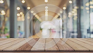 Wooden board on empty table in front of blurred background, perspective brown wood table over blur forest for mockup or product