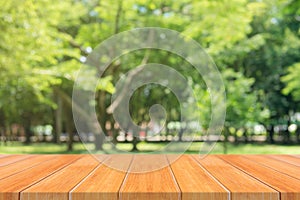 Wooden board empty table in front of blurred background. Perspective brown wood table over blur trees in forest background.