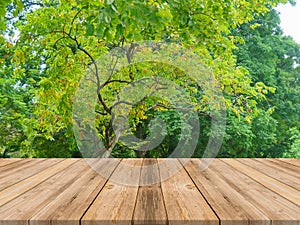 Wooden board empty table in front of forest background. Perspective brown wood over trees in forest - can be used for display or