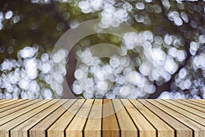 Wooden board empty table in front of natural blurred background. Perspective brown wood over bokeh of tree