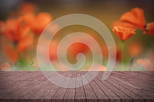 Wooden board empty table in front of orange California poppies. photo